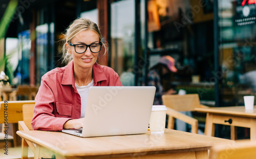 Young attractive caucasian woman sitting in a cafe works on a laptop © Ilona