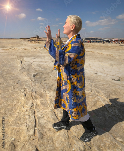 girl in the desert worshiping the sun