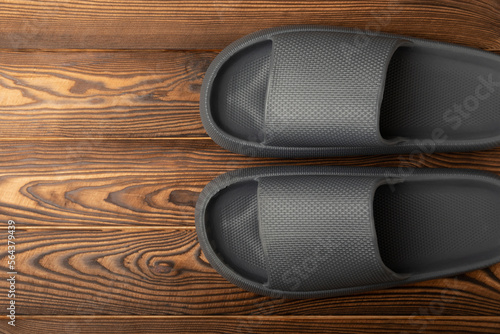 Rubber summer slippers. Replacement shoes for home or office. Yellow slippers on a background of brown space. Relax concepts. Space for text.Space for copy.
