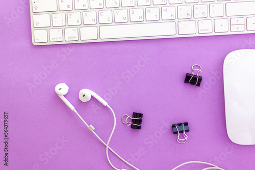 Notepad on the table with keyboard and headphones.