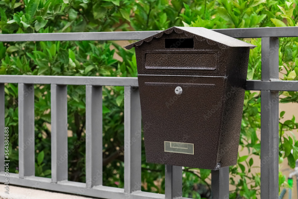 Metal fence with mailbox outdoors, closeup Metal fence with mailbox outdoors, closeup