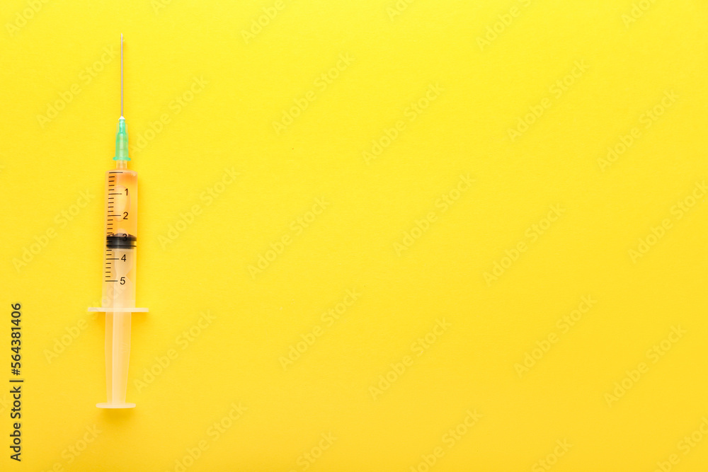 Medical syringe with remedy on yellow background Medical syringe with remedy on yellow background