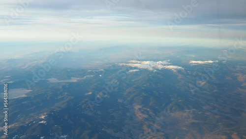 Turkey, Ankara. View from airplane window to the Turkish mountains, lakes and snowy peaks. Layered clouds and horizon. Lakes Saryar, Nallihan and Camlidere. Departure from Esenboga Havalimani Airport photo