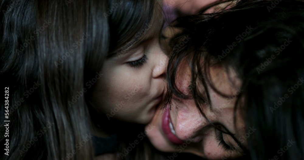 Mother kissing daughter family love and affection