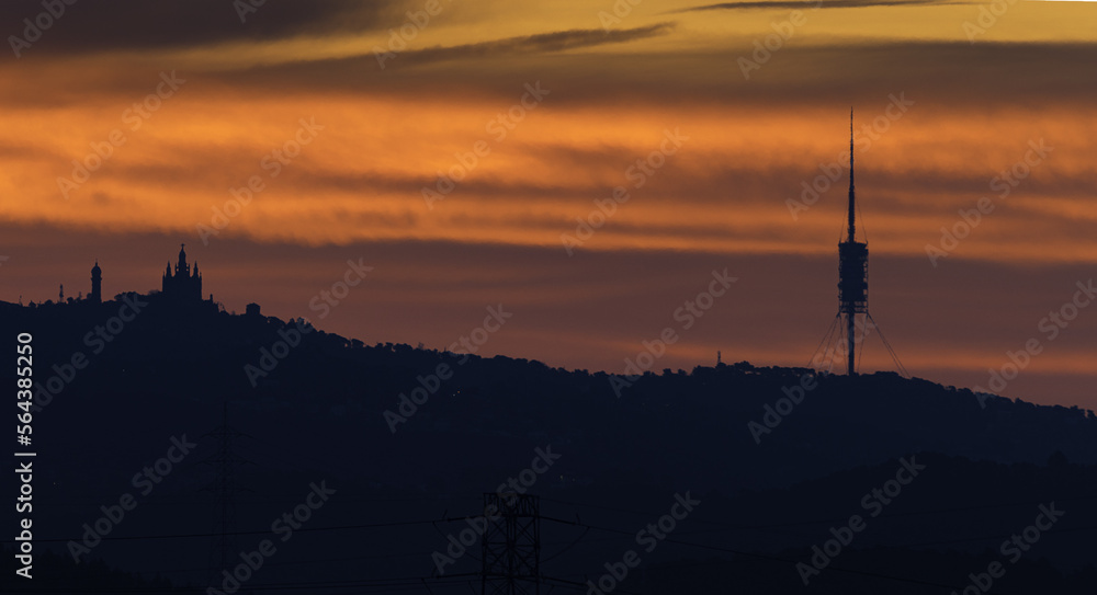 sunrise over the Collserola mountain range with the Barcelona skyline.