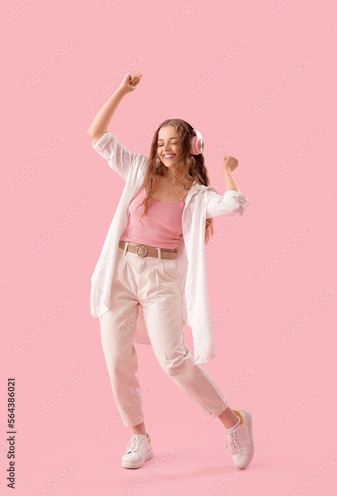 Young woman in headphones dancing on pink background Young woman in headphones dancing on pink background