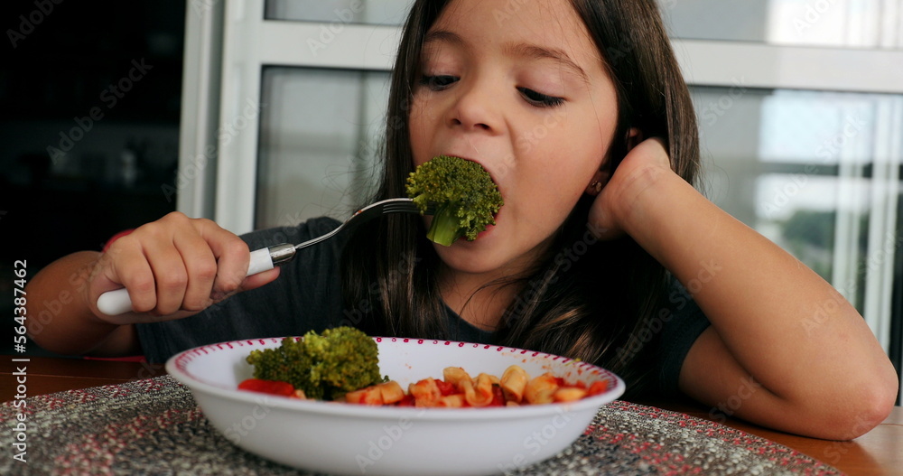 Kid eating broccoli small girl eats healthy vegetable for lunch Kid eating broccoli small girl eats healthy vegetable for lunch