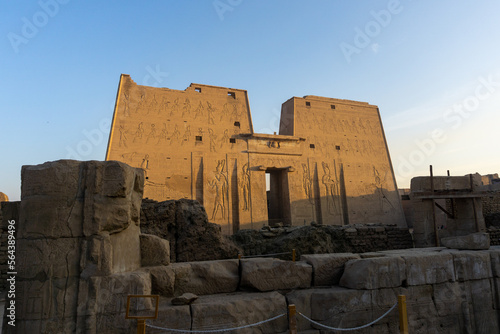 Exterior of the Edfu temple at dawn, with sunlight illuminating the main facade.
