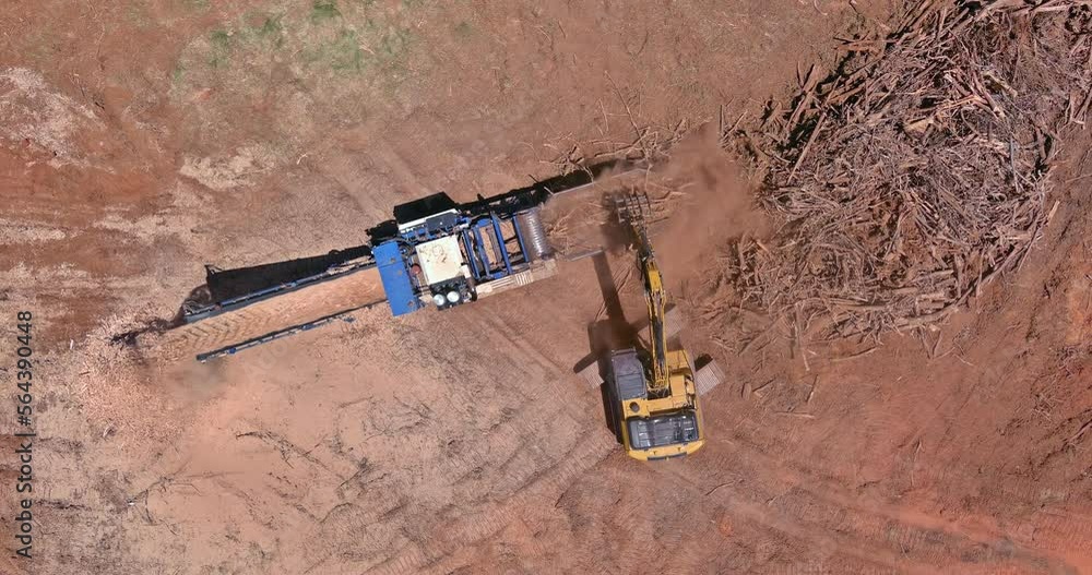 Large industrial shredder machine employed in order to shred roots into chips so that land can prepared for housing development Large industrial shredder machine employed in order to shred roots into chips so that land can prepared for housing development