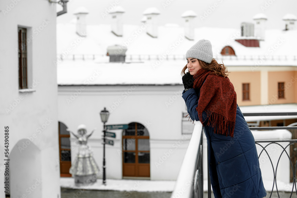 Young happy woman enjoying winter weather wearing scarf and knitted hat. Young happy woman enjoying winter weather wearing scarf and knitted hat.