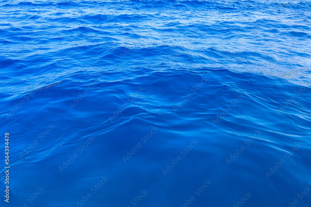 Naklejka premium Very nice sea water background or backdrop with selective focus. Small waves of natural water surface texture.