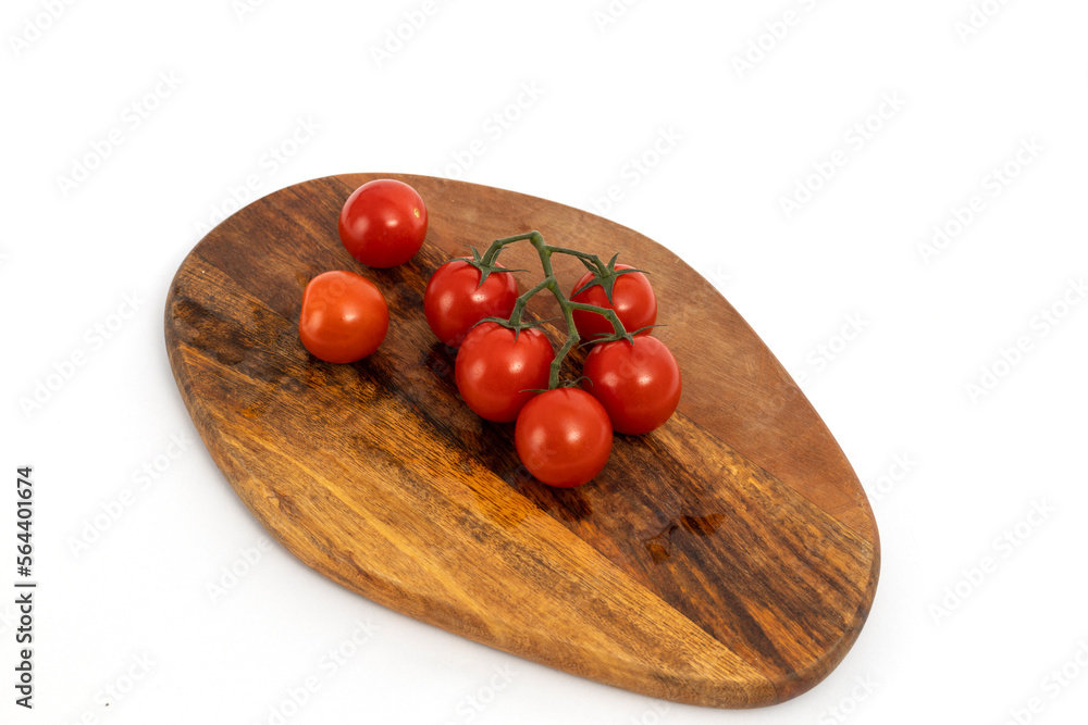 Cherry tomatoes on wooden chopping board on white background isolated Cherry tomatoes on wooden chopping board on white background isolated