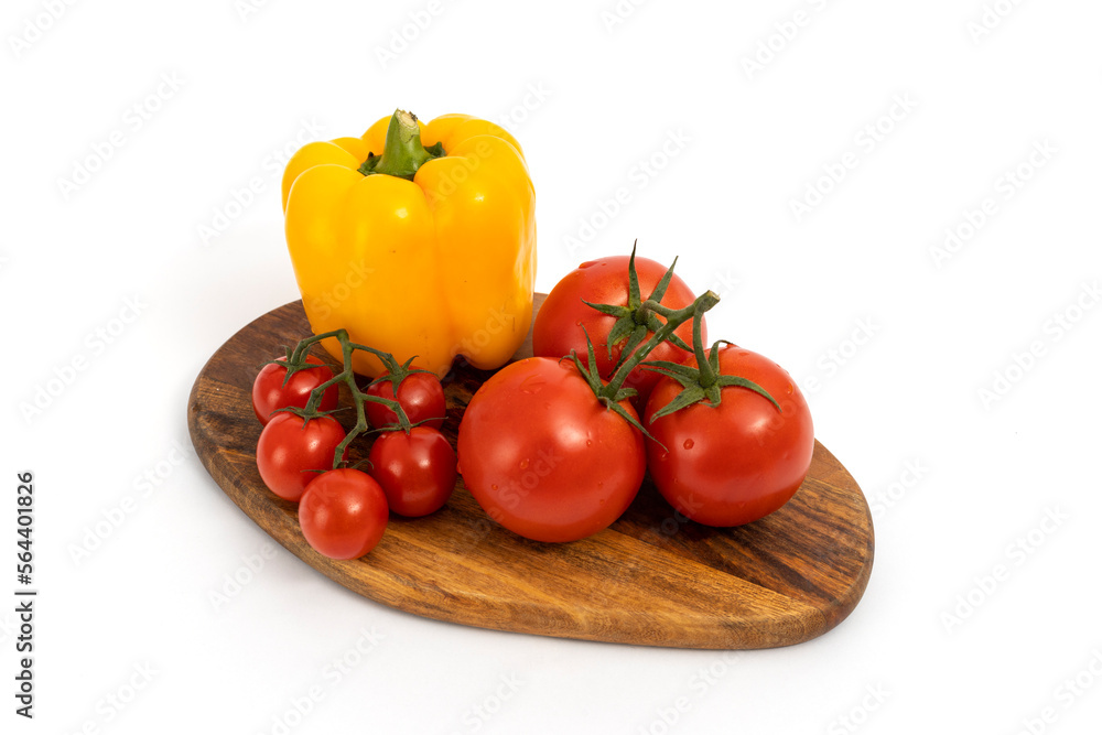 Yellow pepper and cherry tomatoes on wooden chopping board on white background isolated Yellow pepper and cherry tomatoes on wooden chopping board on white background isolated