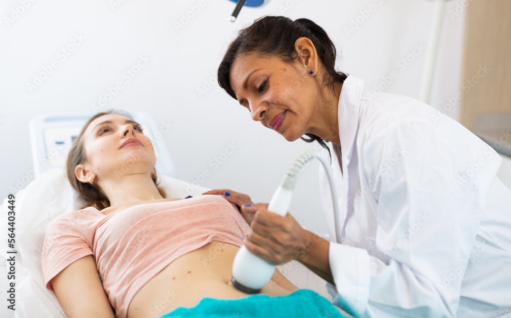 Fototapeta premium Portrait of female doctor performing electroporation mesotherapy body treatment to woman at aesthetic clinic