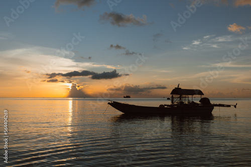 Romantic sunset on tropical island with boat