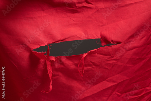 Canvas Print red fabric with big hole and shredded threads, ripped open hole at center of a r