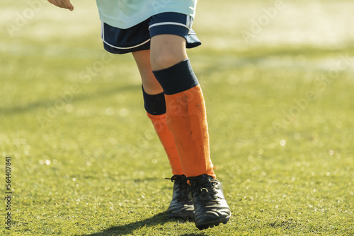 Fototapeta Naklejka Na Ścianę i Meble -  leg children run play soccer orange footwear grass stadium
