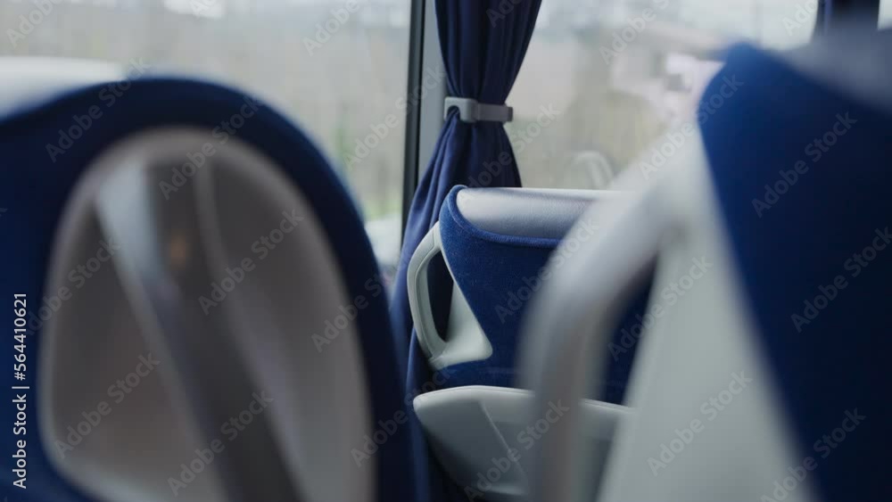 Ride on long distance bus seats with highway and cars in background at window. Driving down a highway or road. Comfortable blue seats or chairs on liner public bus for long rides or transport Ride on long distance bus seats with highway and cars in background at window. Driving down a highway or road. Comfortable blue seats or chairs on liner public bus for long rides or transport