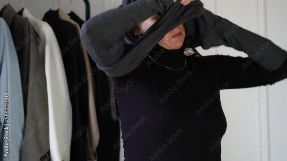Woman trying on clothes in the morning before going to work, indecision Woman trying on clothes in the morning before going to work, indecision