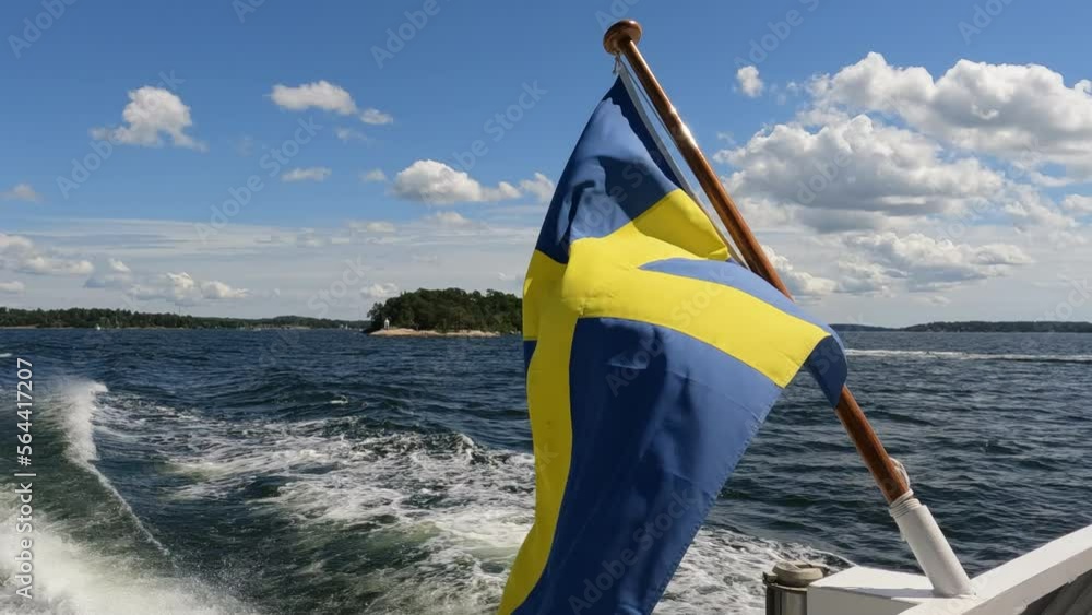 Swedish flag waving on rear of boat underway in Stockholm Archipelago. Close up video of flag on right side