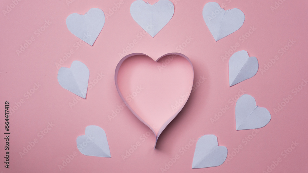 Composition for Valentine's Day February 14th. Delicate pink background and pink hearts cut out of paper.