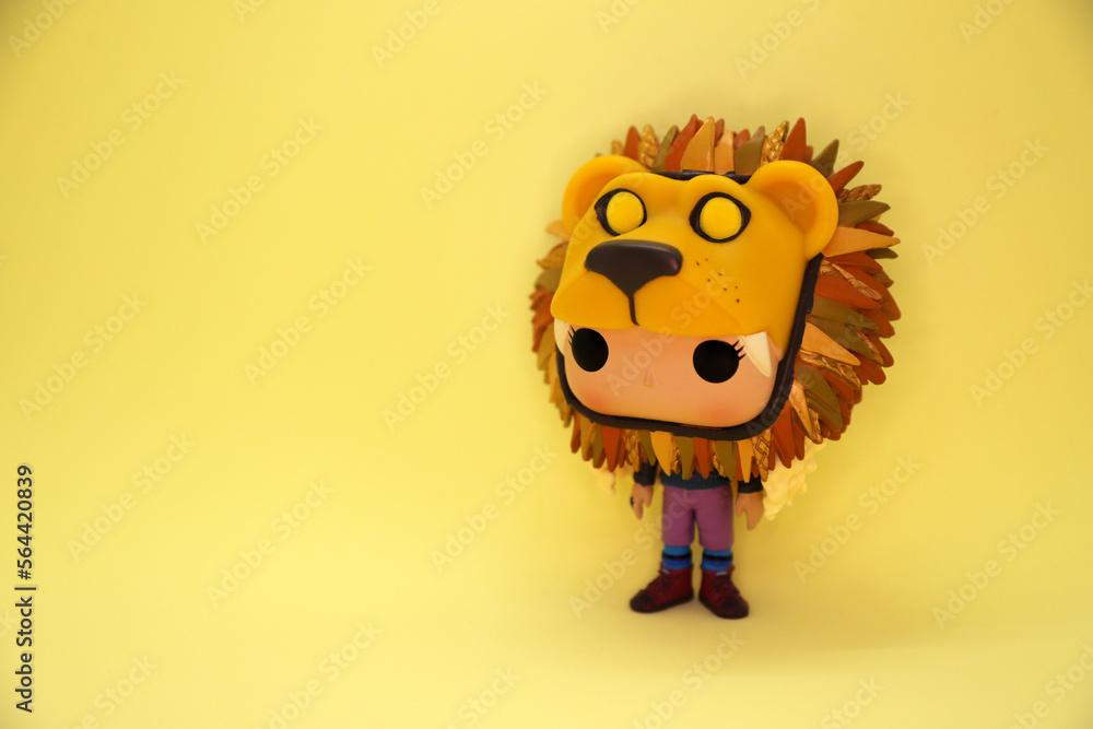 Fototapeta premium Funko Pop Luna Lovegood with lion costume. Harry Potter character. collectible toy Collection doll. Ravenclaw house student. Yellow background. Isolated. The Quibbler Magazine.