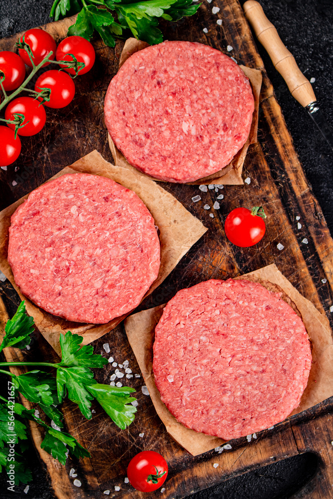 A raw burger on a tomato cutting board. A raw burger on a tomato cutting board.
