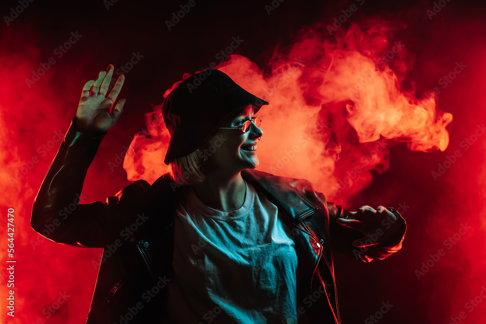 Fashionable woman dancing in red neon light, smoke background. Z generation