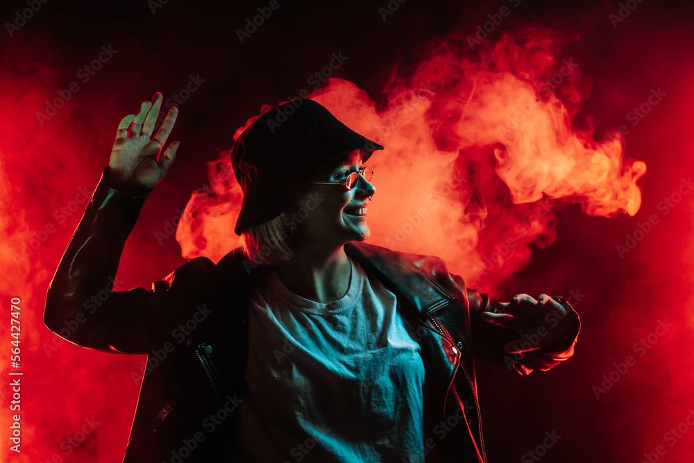 Fashionable woman dancing in red neon light, smoke background. Z generation Fashionable woman dancing in red neon light, smoke background. Z generation