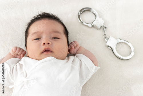 起きている赤ちゃんと玩具の手錠（0歳1か月、日本人、男の子） photo