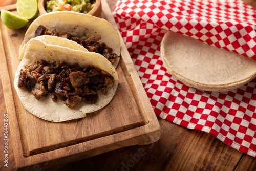 Tacos de Bistec. Homemade grilled meat in a corn tortilla. Street food from Mexico, traditionally accompanied with cilantro, onion and spicy sauce or guacamole photo