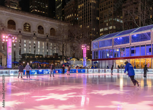 People skating on an outdoor rink in Bryant Park, New York City, at night