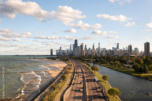 Downtown Chicago city skyline aerial centered over traffic along Lake Shore Drive between South Lagoon and Lake Michigan on a sunny day with fluffy white clouds in a blue sky above. photo