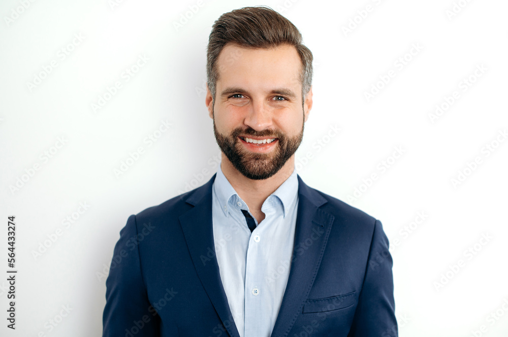 Close-up photo of a confident handsome bearded caucasian businessman, corporate executive, ceo, in formal elegant suit, stand on isolated white background, looks at camera, smiling friendly Close-up photo of a confident handsome bearded caucasian businessman, corporate executive, ceo, in formal elegant suit, stand on isolated white background, looks at camera, smiling friendly