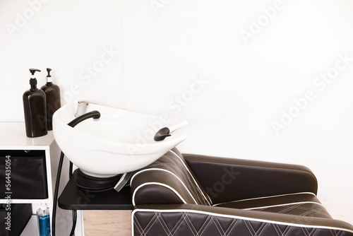 Modern wash unit with professional care products in barbershop