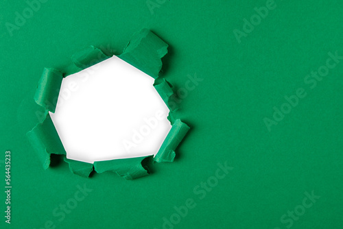 green and white Hole in the paper with torn sides.