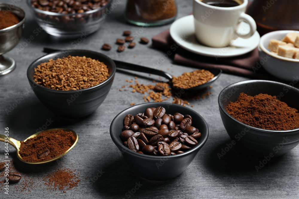 Bowls of beans, instant and ground coffee on grey table Bowls of beans, instant and ground coffee on grey table