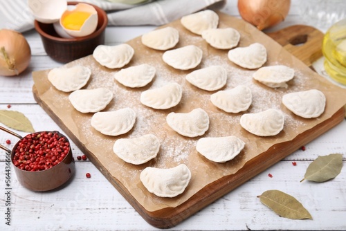 Raw dumplings (varenyky) with tasty filling and ingredients on white wooden table