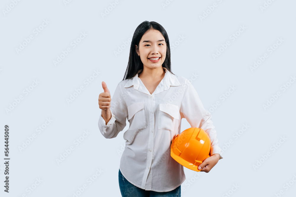 Young female engineer in helmet stand with thumb up posture Young female engineer in helmet stand with thumb up posture
