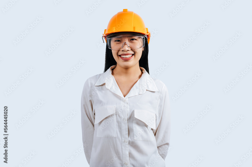 Young female engineer wearing yellow helmet stand with charming smile posture Young female engineer wearing yellow helmet stand with charming smile posture