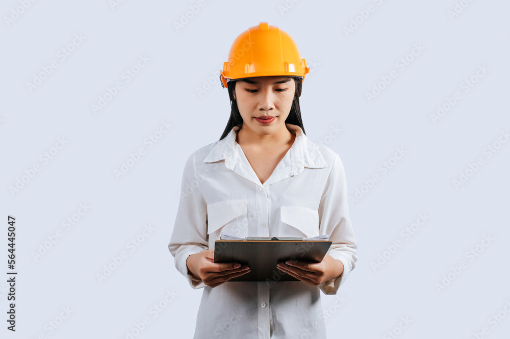 Young female engineer wearing Yellow helmet and clipboard Young female engineer wearing Yellow helmet and clipboard