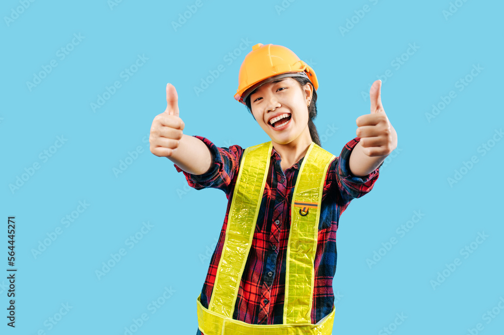 Young female engineer in helmet stand with thumb up posture