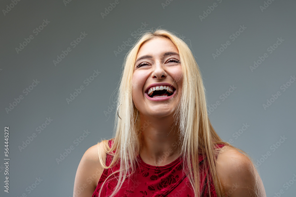 Blond woman laughing joyfully in red dress Blond woman laughing joyfully in red dress
