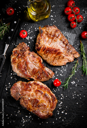 Grilled pork steak with cherry tomatoes and rosemary. 