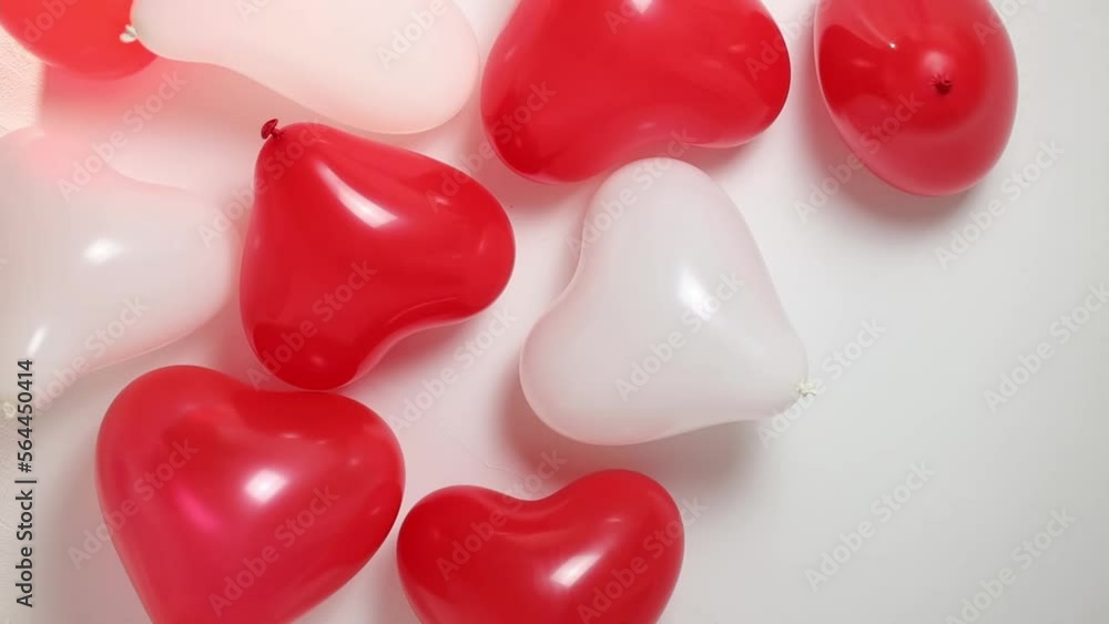 Lots of red and white heart balloons on the ceiling in the room,close-up view from below with tracking to the right.Valnetin's day concept. Lots of red and white heart balloons on the ceiling in the room,close-up view from below with tracking to the right.Valnetin's day concept.