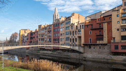 Colorful houses reflected in the Onyar river, in Girona, Catalonia, Spain. Church of Sant Feliu and Cathedral of Santa María in the background © martinscphoto