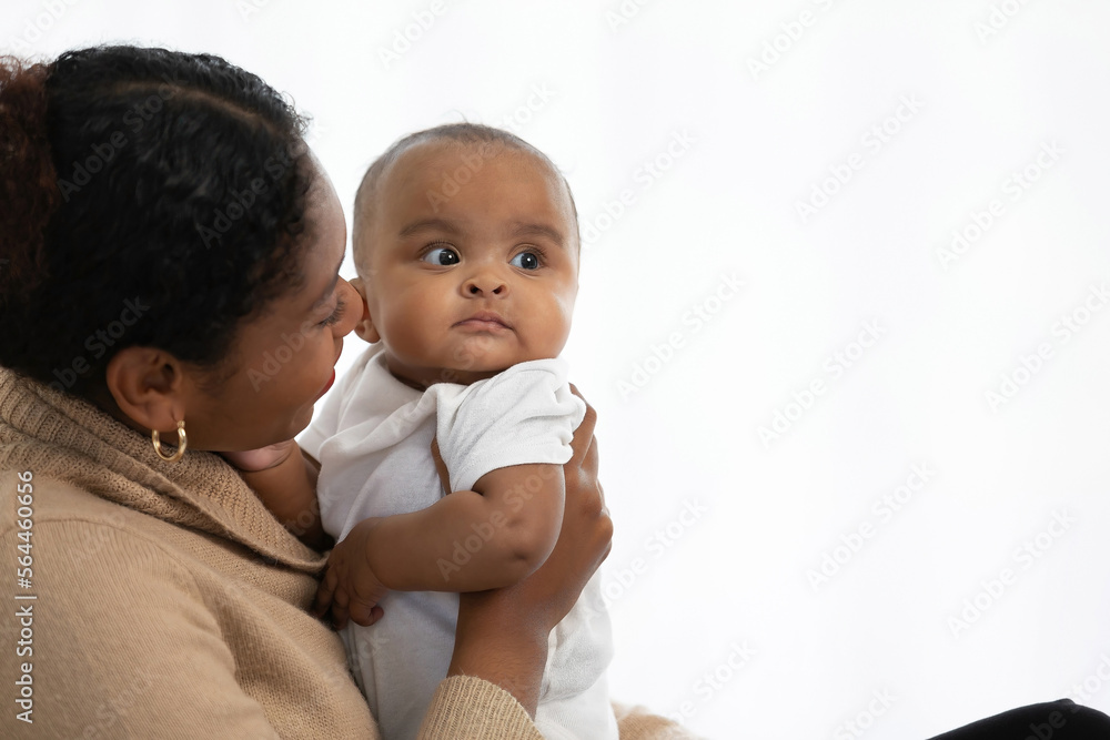 African young mother playing with her adorable baby on bed African young mother playing with her adorable baby on bed