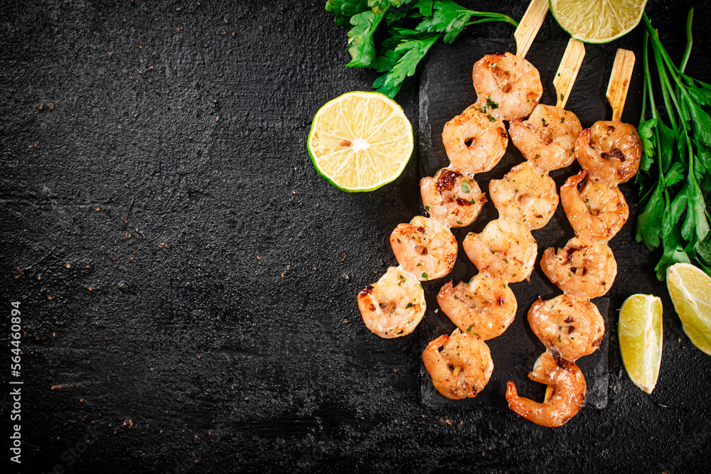 Grilled shrimp on a stone board with parsley and lime. Grilled shrimp on a stone board with parsley and lime.