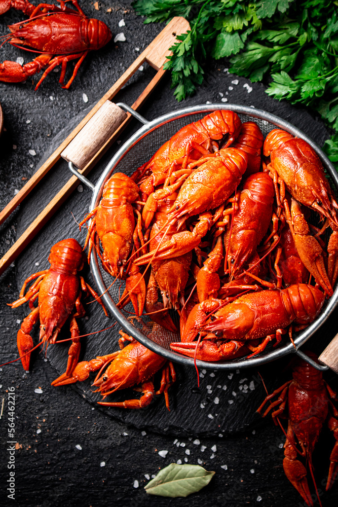 Boiled crayfish in a colander on a stone board. Boiled crayfish in a colander on a stone board.