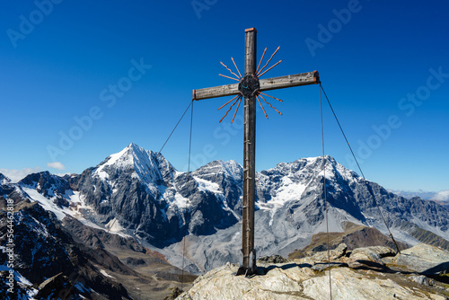 Bild auf Leinwand Summit cross on the Madritschspitze in South Tyrol, Italy, with the Ortler and t